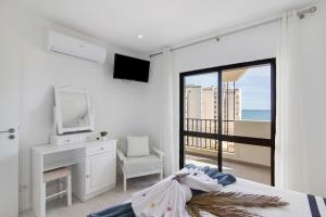 a bedroom with a bed and a desk and a television at Luxury Beach View - Praia da Rocha in Portimão