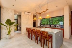 a kitchen with a large island with bar chairs at * Dream Villa on Private Cenote 10min to Beach in Akumal