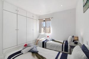two beds in a room with white cabinets at Luxury Beach View - Praia da Rocha in Portimão +16 photos
