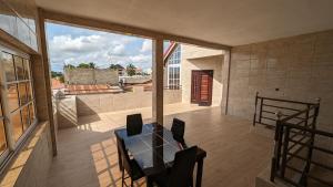 patio con mesa y sillas en el balcón en Clarisse Lodge, en Lomé