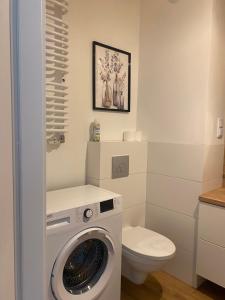 y baño con lavadora y aseo. en Airport Green Apartment KL21 - free parking, en Varsovia