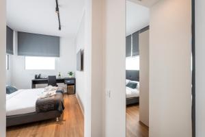 a bedroom with white walls and a bed and a desk at BnButler - InBrera Suites - Giulianova, 1 in Milan