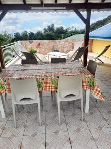 einen Tisch und Stühle auf einer Terrasse in der Unterkunft Propriete de 3 chambres avec vue sur la mer jardin amenage et wifi a Vieux Fort in Vieux-Fort