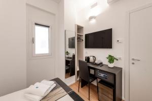 - une chambre avec un bureau et un lit avec une télévision dans l'établissement BnButler - InBrera Suites - Giulianova, 1, à Milan
