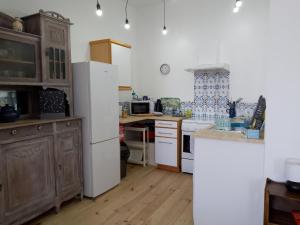 a kitchen with a white refrigerator and a sink at Pyrenees Vue Gite - Vues Fantastique, Parking Gratuit Sur Place & Piscine in Saint-Gaudens
