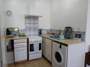a kitchen with a stove and a washing machine at Pyrenees Vue Gite - Vues Fantastique, Parking Gratuit Sur Place & Piscine in Saint-Gaudens