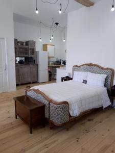 a bedroom with a large bed and a kitchen at Pyrenees Vue Gite - Vues Fantastique, Parking Gratuit Sur Place & Piscine in Saint-Gaudens