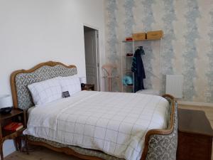 ein Schlafzimmer mit einem Bett mit einer weißen Bettdecke in der Unterkunft Pyrenees View - Vues Fantastique, Parking Gratuit Sur Place Et Près De La Ville 50m2 in Saint-Gaudens