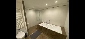 a bathroom with a bath tub and a toilet at B&B - Villa des Remparts - Ardres proche Calais-St Omer-Dunkerque in Ardres +61 photos