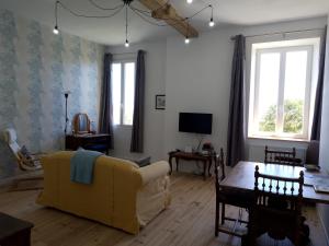 a living room with a yellow couch and a table at Pyrenees Vue Gite - Vues Fantastique, Parking Gratuit Sur Place & Piscine in Saint-Gaudens