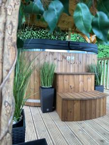a wooden fence with two potted plants on a deck at Southwell Retreat Glamping Pods in Southwell