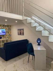 uma sala de estar com um sofá azul e escadas em magica Home Cannizzaro em Catânia