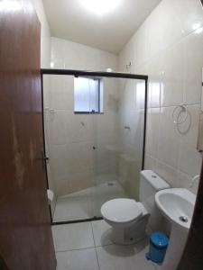a bathroom with a shower and a toilet and a sink at Estúdio Charmoso no Centro de Apiaí in Apiaí