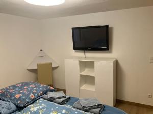 a bedroom with a bed and a tv on the wall at Romantikurlaub im Weindorf Kiedrich in Kiedrich