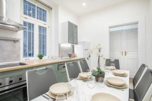 cocina blanca con mesa con sillas y encimera de cocina en Full comfort, 4 bedrooms in the heart of the city, en Budapest 33 fotos más