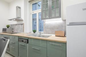 a kitchen with green cabinets and a sink at Full comfort, 4 bedrooms in the heart of the city in Budapest