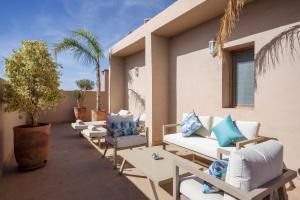 a patio with couches and chairs and a palm tree at dar al walidine in Marrakesh