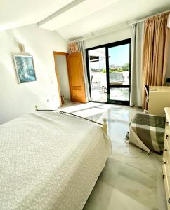 ein Schlafzimmer mit einem Bett und einem großen Fenster in der Unterkunft Penthouse Benalmadena Arroyo de la Miel centro in Benalmádena