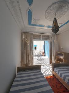 1 dormitorio con 2 camas y sala de estar en CampSurf Morocco, en Tamraght Ouzdar