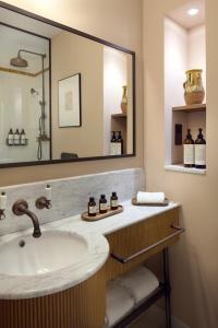 La salle de bains est pourvue d'un lavabo et d'un grand miroir. dans l'établissement Le Grand Hôtel Cayré, à Paris