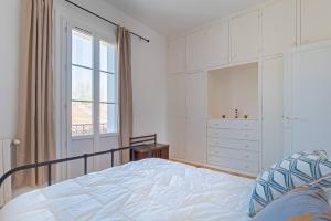 ein Schlafzimmer mit einem Bett, einer Kommode und einem Fenster in der Unterkunft L'Atelier Pop, Beau T3, Quartier des Beaux Arts in Montpellier