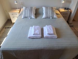 Una cama grande con dos toallas blancas. en Espectacular ubicación con terraza propia en Mendoza