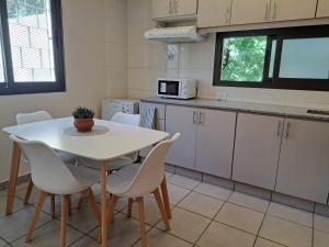 cocina con mesa blanca y sillas blancas en Espectacular ubicación con terraza propia en Mendoza