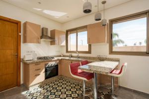 a kitchen with a table and red chairs at dar al walidine in Marrakesh