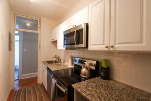 a kitchen with a stove and a microwave at Sun-filled W City Views Public Transportation in Boston