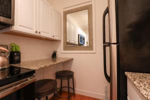 a kitchen with a black refrigerator and stools in it at Sun-filled W City Views Public Transportation in Boston