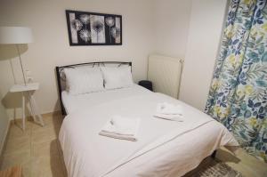 - une petite chambre avec un lit et des serviettes dans l'établissement Georgia's lakeside house, à Kastoria
