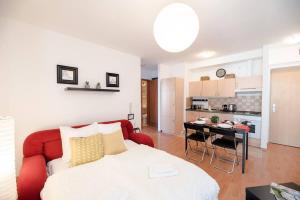 a living room with a red couch and a kitchen at Bright and homey AC apartment near the center in Budapest
