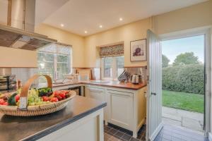 a kitchen with a bowl of fruit on a counter at Gardeners Cottage - Hot Tub Packages Available in Market Harborough