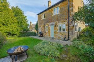 a brick house with a table in front of it at Gardeners Cottage - Hot Tub Packages Available in Market Harborough