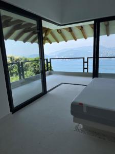 a room with a balcony with a view of the ocean at Welcome to the Jungle in Zihuatanejo