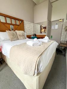 a bedroom with two beds with towels on them at X Hotel Brunswick Square in Brighton & Hove