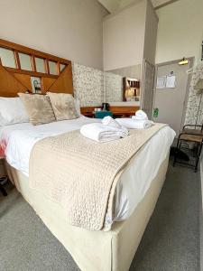 a bedroom with two beds with towels on them at The X Hotel Brunswick Square in Brighton & Hove