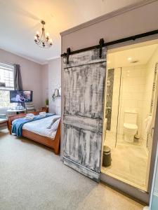 a bedroom with a bed and a glass door leading to a bathroom at The X Hotel Brunswick Square in Brighton & Hove +29 photos