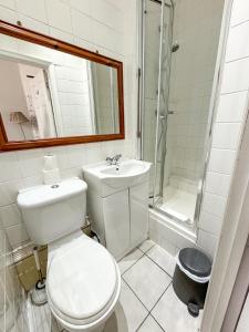 uma casa de banho com um WC, um lavatório e um chuveiro em X Hotel Brunswick Square em Brighton & Hove