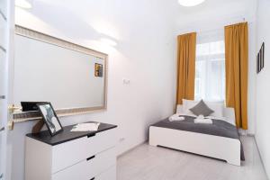 a bedroom with a bed and a dresser and a mirror at Central and New design apartment in Budapest