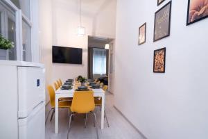 a dining room with a table and yellow chairs at Central and New design apartment in Budapest