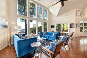 een woonkamer met blauwe meubels en grote ramen bij Birds Eye Retreat-10 acres on Beaver Lake-Hot Tub in Rogers