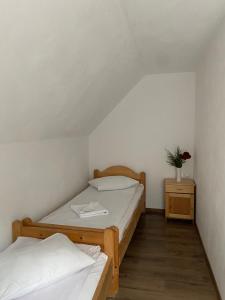 two beds in a small room with a flower on a night stand at Casa de Vacanţă Vârtop in Vartop
