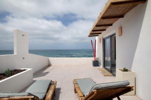 Un balcón con sillas y vistas al océano. en Casa Lua, en Santa María de Guía de Gran Canaria