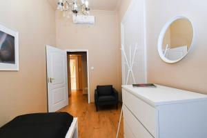a bedroom with a dresser and a mirror and a chair at Very central very spacious new home in Budapest
