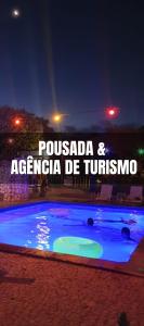 a swimming pool at night with the words possada and argacionza de at Bonito HI Hostel e Pousada in Bonito