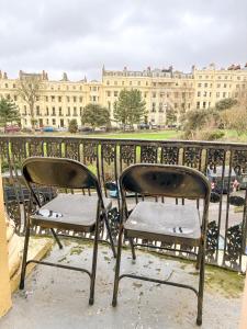 2 sillas sentadas en un balcón frente a un edificio en X Hotel Brunswick Square, en Brighton & Hove