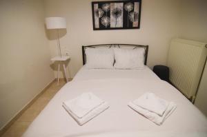 - un lit blanc avec 2 serviettes blanches dans l'établissement Georgia's lakeside house, à Kastoria