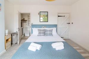 sypialnia z niebiesko-białym łóżkiem z 2 poduszkami w obiekcie Hygge House Cosy 3 Bedroom 2 Bathroom Townhouse w mieście Kegworth