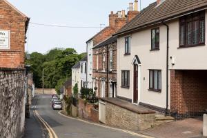 a street in a town with houses and a car at Hygge House Cosy 3 Bedroom 2 Bathroom Townhouse in Kegworth